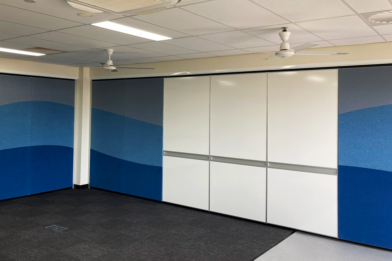 solid operable wall with whiteboards and fabric panels